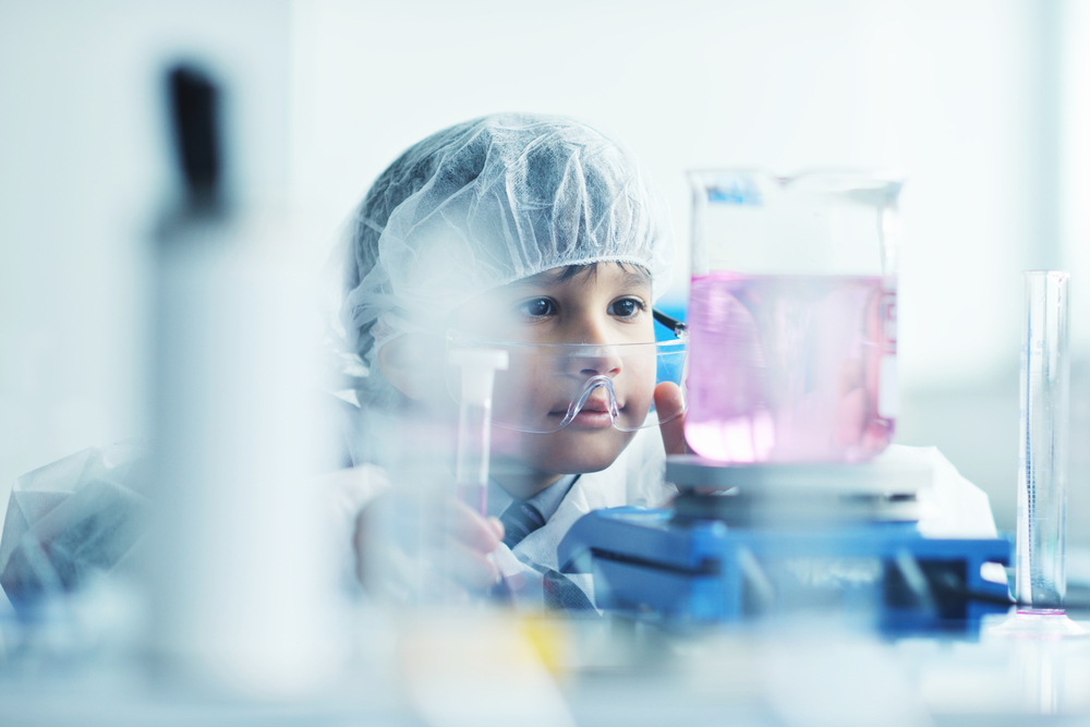 cute little male child have experiment with test tubes in bright modern lab